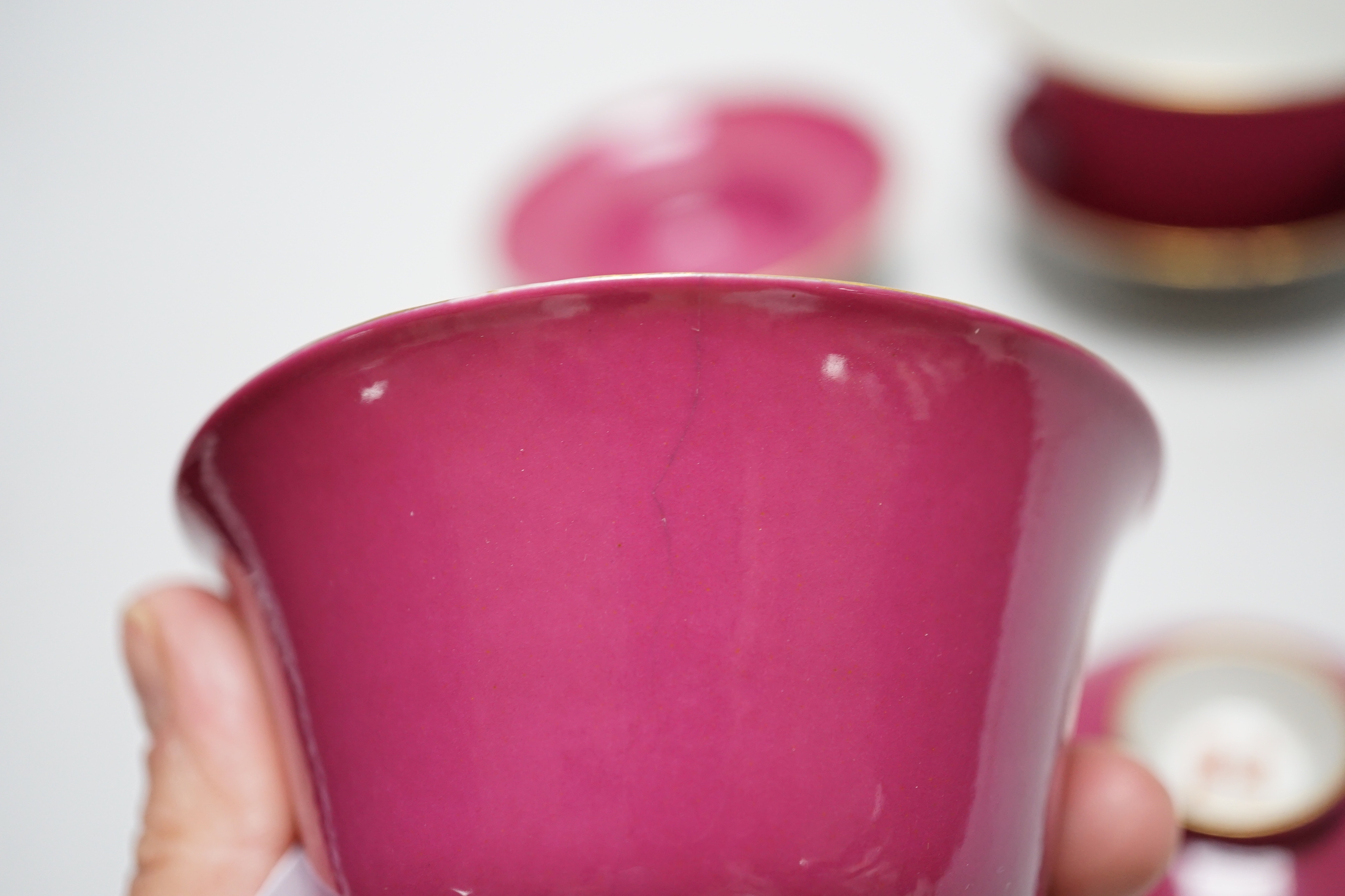 A pair of Chinese ruby ground tea bowls, covers and stands